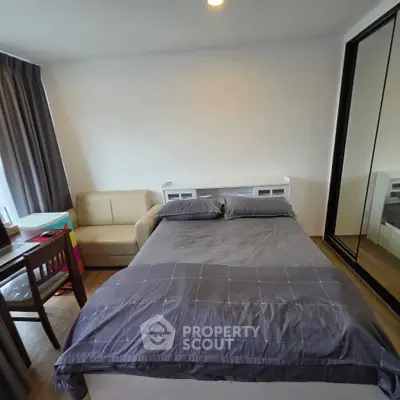 Cozy bedroom with modern furnishings and mirrored wardrobe in a stylish apartment