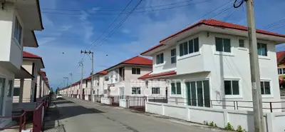 Charming suburban neighborhood with modern two-story homes and red roofs under a clear blue sky.