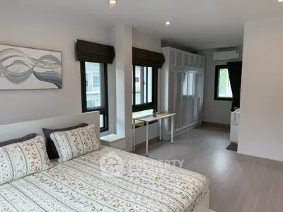 Spacious modern bedroom with large windows and stylish decor