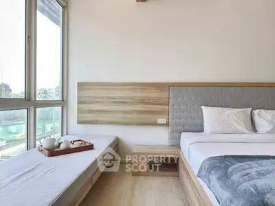 Modern bedroom with large windows and cozy seating area