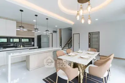 Modern open-layout kitchen and dining area with elegant lighting and sleek design.