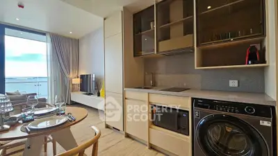Modern open-plan kitchen and living room with ocean view balcony in luxury apartment
