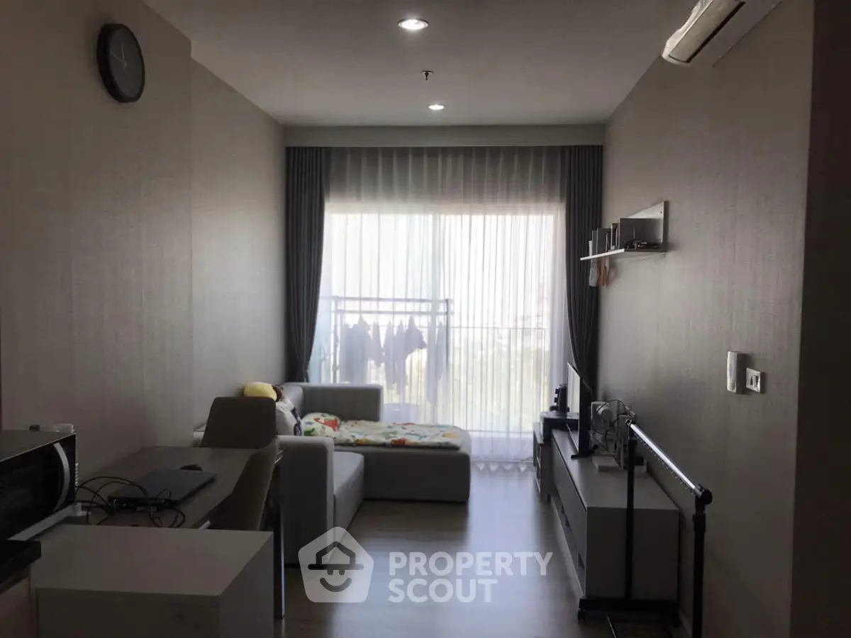 Modern living room with large window and cozy sofa in a stylish apartment.