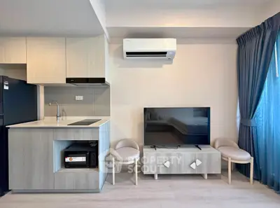 Modern living room with sleek kitchen and stylish furniture in a contemporary apartment.