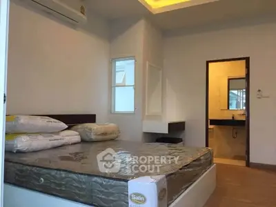 Modern bedroom with ensuite bathroom featuring minimalist design and natural lighting.