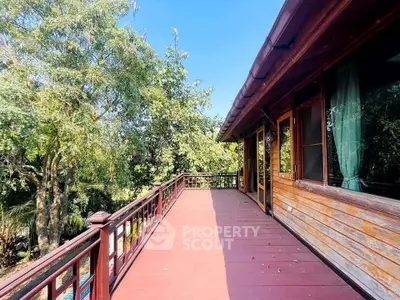 Spacious wooden balcony with scenic forest view, perfect for relaxation and outdoor enjoyment.