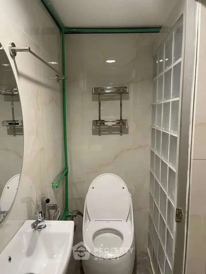 Modern bathroom with sleek fixtures and glass block wall for a stylish touch.