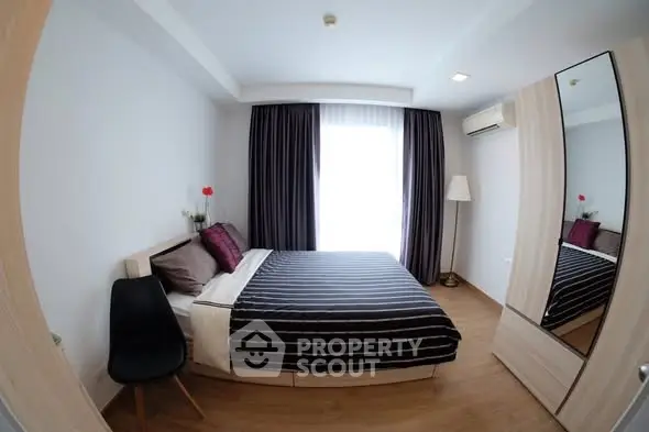 Modern bedroom with stylish decor and ample natural light, featuring a cozy bed and sleek furnishings.
