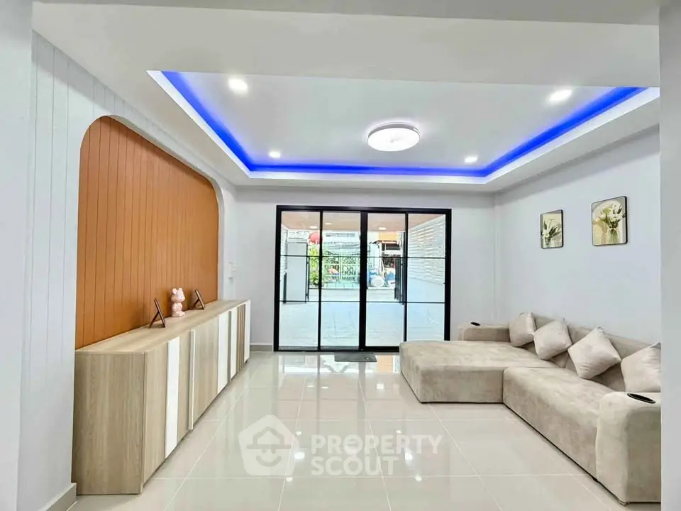 Modern living room with stylish ceiling lights and cozy beige sectional sofa.