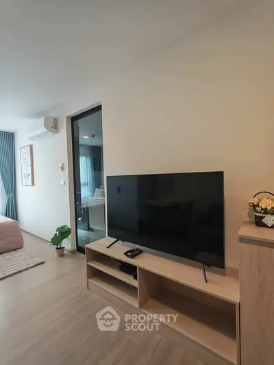 Modern living room with sleek TV stand and cozy bedroom view