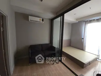 Modern studio apartment with sliding glass partition and cozy furnishings