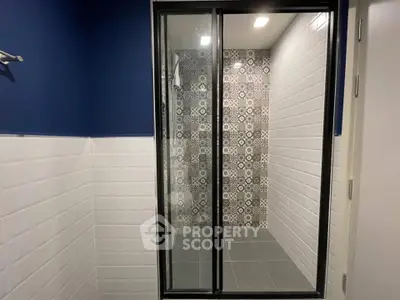 Modern bathroom with stylish tiled shower and sleek glass door