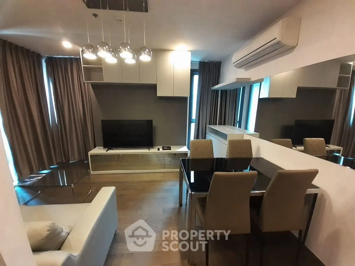 Modern living room with sleek furniture and air conditioning, featuring a stylish dining area.