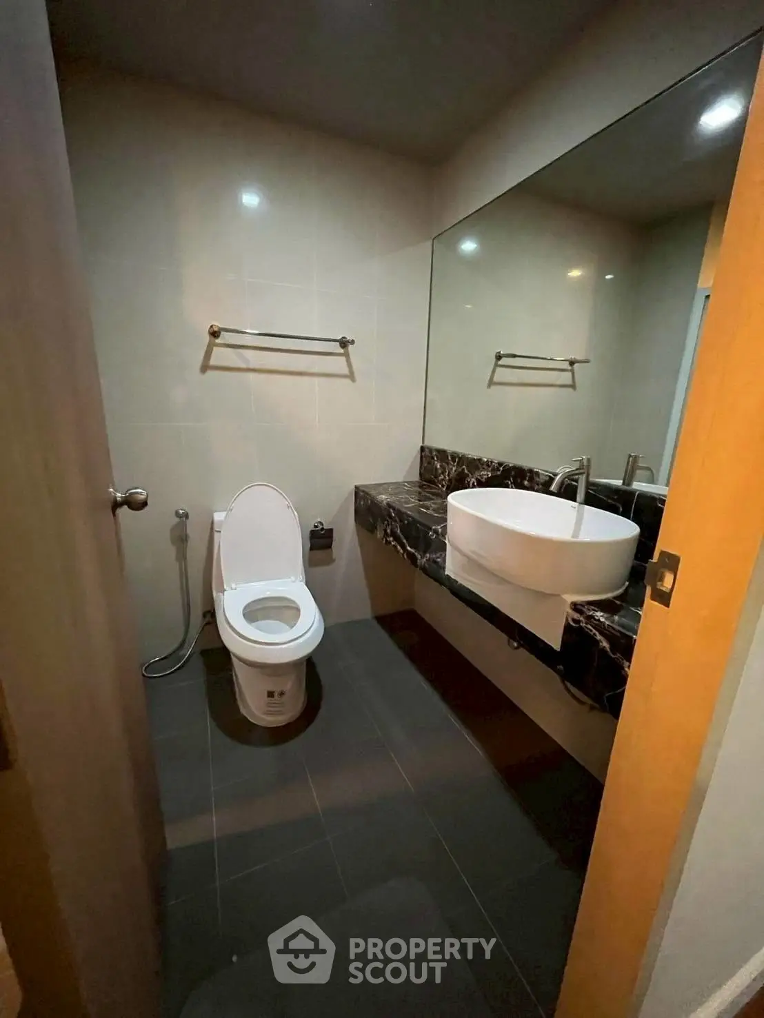 Modern bathroom with sleek fixtures and large mirror, perfect for contemporary living.