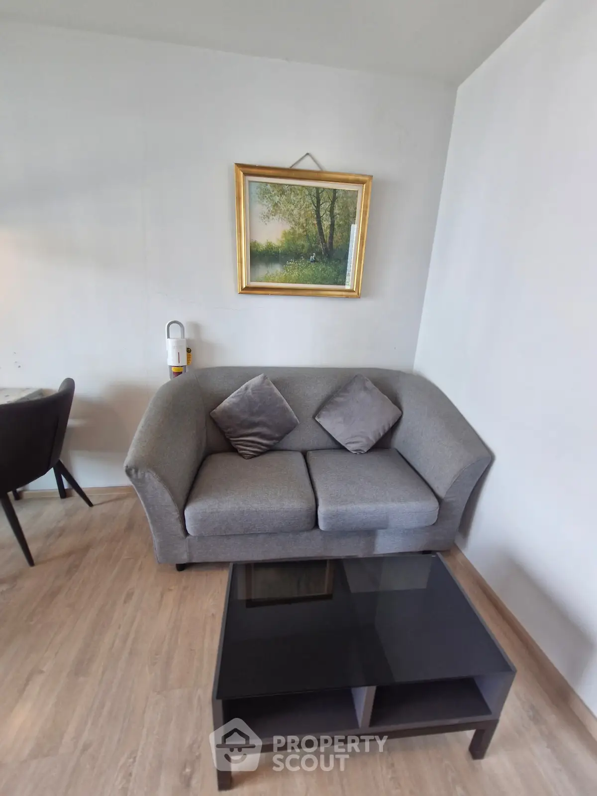 Cozy living room with modern gray sofa and elegant wall art, perfect for relaxation.