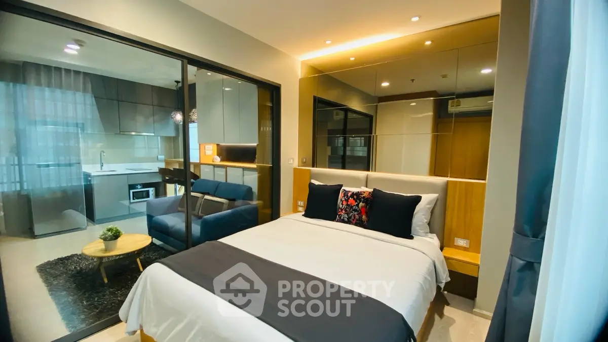 Modern studio apartment with stylish bedroom and open kitchen layout.