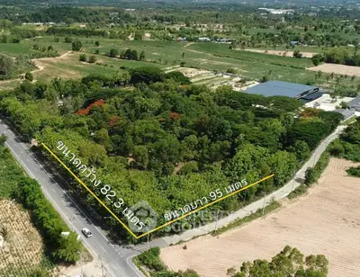Expansive aerial view of lush green land plot with road access, ideal for development opportunities.