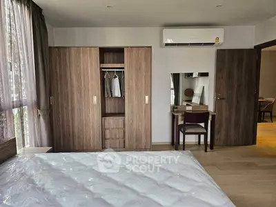 Spacious bedroom with modern wardrobe and air conditioning in a stylish apartment.