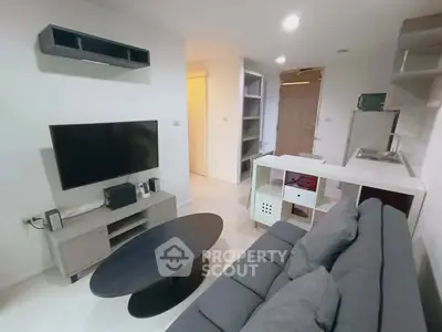 Modern living room with sleek furniture and open layout, featuring a wall-mounted TV and stylish shelving.