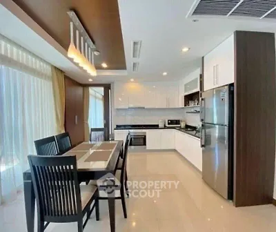 Modern kitchen with dining area, sleek cabinetry, and stainless steel appliances.