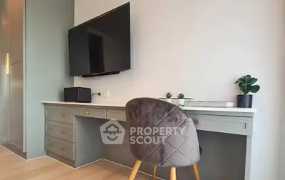 Modern study area with sleek desk, wall-mounted TV, and stylish chair in a contemporary home.