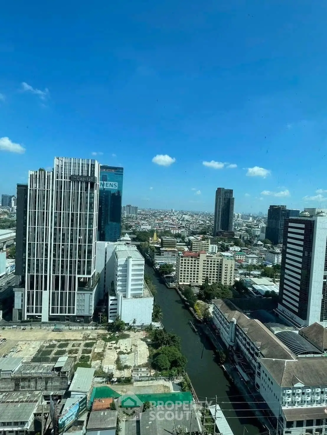 Stunning cityscape view from high-rise building overlooking river and skyline.