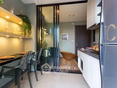 Modern kitchen with sleek design and open layout, featuring glass dining table and stylish decor.