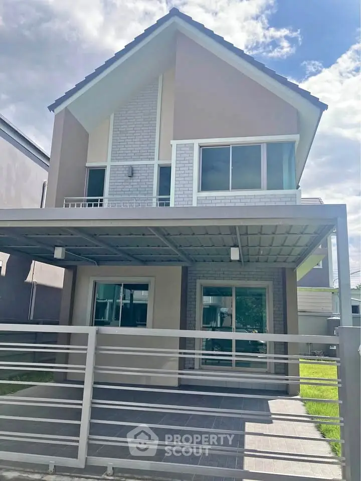 Modern two-story house with a spacious carport and stylish facade.
