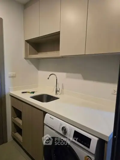Modern kitchen with sleek cabinetry and built-in washing machine