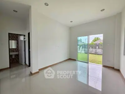 Spacious unfurnished room with large windows and garden view, perfect for customization.