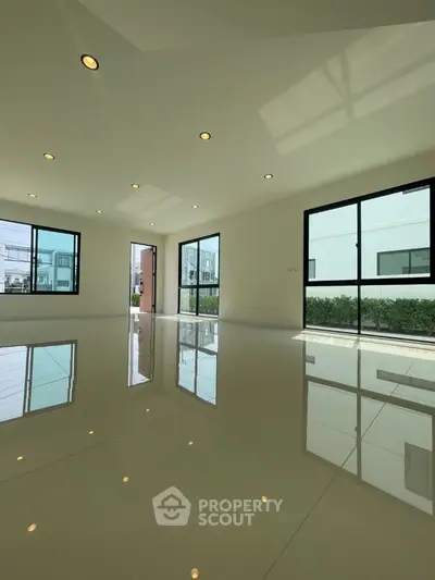 Spacious modern living room with large windows and glossy tiled floor