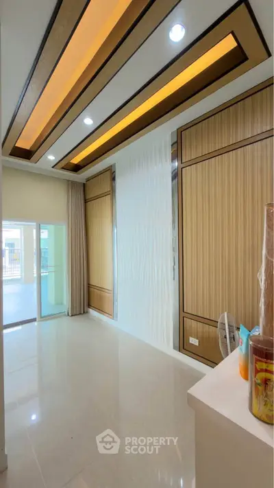 Modern interior with elegant ceiling design and large windows for natural light.