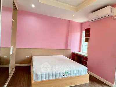 Spacious bedroom with pink walls, large window, and modern air conditioning unit.