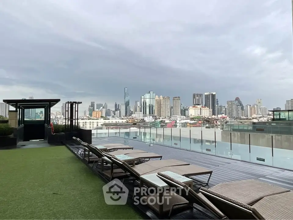 Luxurious rooftop with stunning city skyline view and modern lounge chairs.