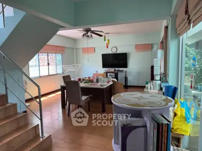 Spacious living room with dining area, featuring natural light and modern decor.