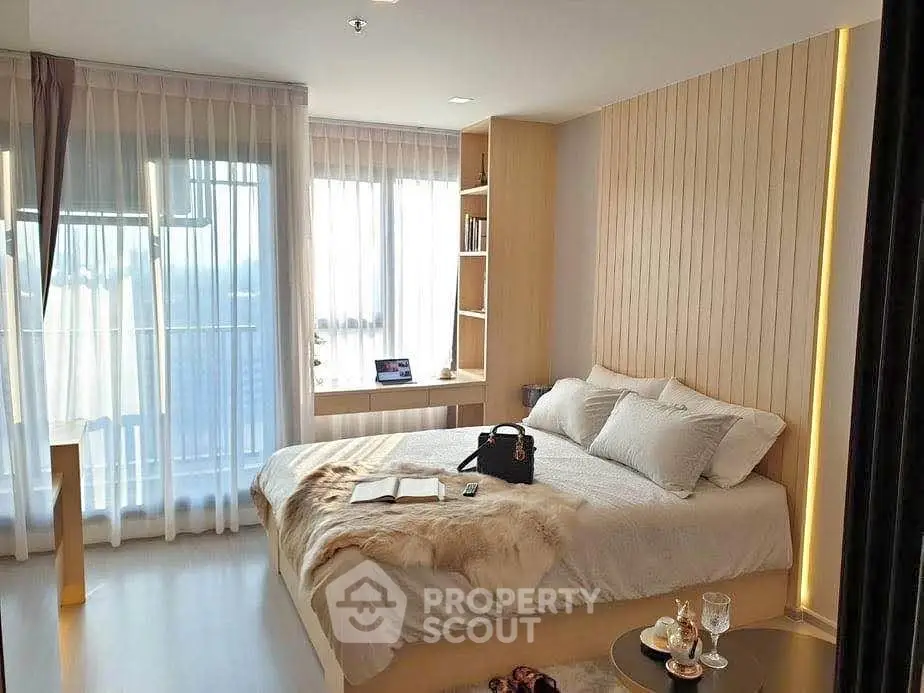 Luxurious bedroom with modern decor and large windows offering natural light.