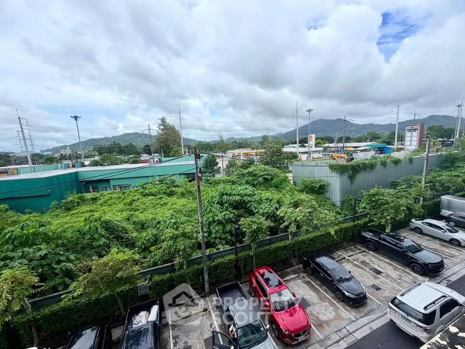 Scenic view from a property overlooking lush greenery and parking area, ideal for nature lovers.