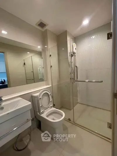 Modern bathroom with glass shower enclosure and sleek fixtures