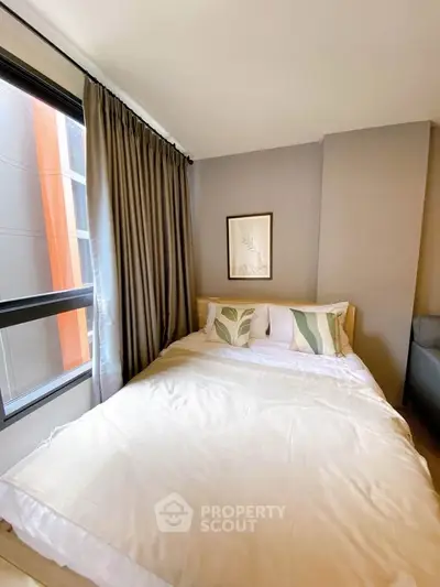 Cozy bedroom with large window and stylish decor in modern apartment
