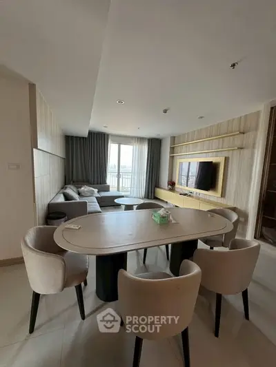 Modern living room with elegant dining area and large windows offering natural light.
