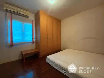 Cozy bedroom with large wooden wardrobe and comfortable bed, perfect for restful nights in a serene residential setting.