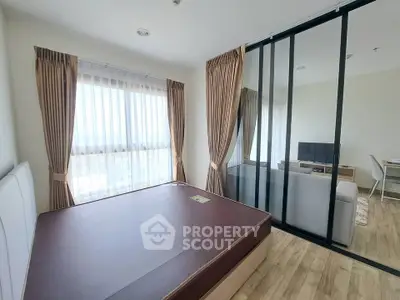 Modern apartment with spacious bedroom and sliding glass doors leading to a cozy living area.