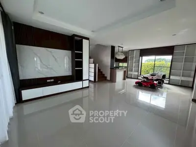 Spacious modern living room with sleek design and large windows offering natural light and garden view.