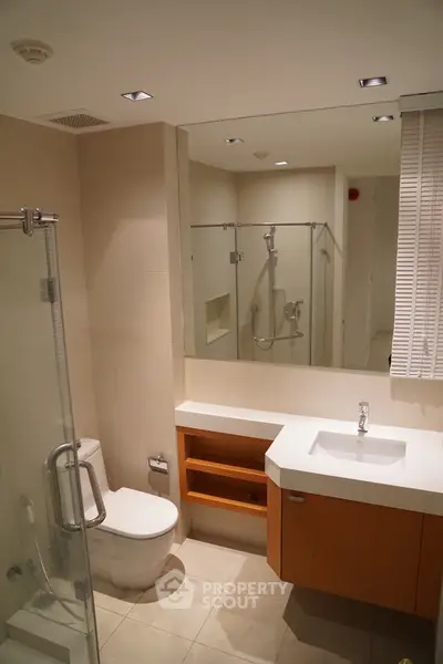 Modern bathroom with glass shower and sleek vanity in a contemporary home.