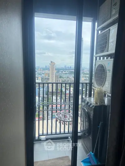 High-rise balcony with city view and laundry appliances, perfect urban living.