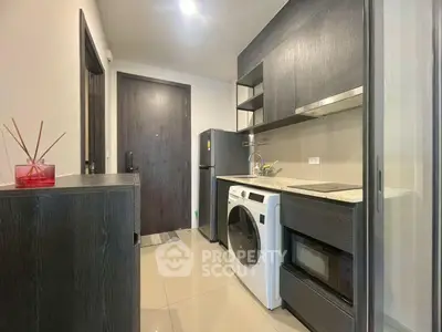 Modern compact kitchen with sleek cabinetry and integrated appliances in a stylish apartment.