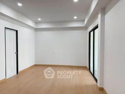 Spacious unfurnished room with wooden flooring and large windows