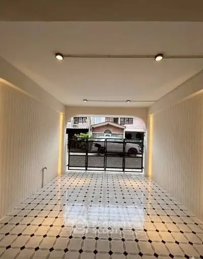 Spacious interior with elegant tiled flooring and large windows offering street view.