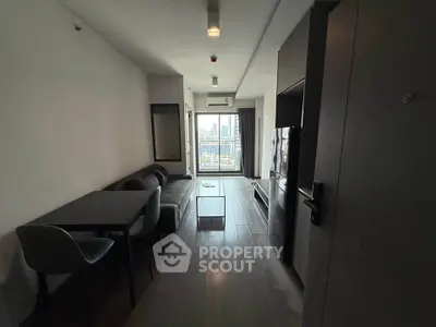 Modern living room with city view, sleek furniture, and open layout in urban apartment.
