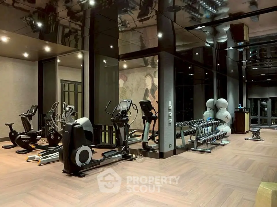 Luxurious gym with modern equipment and mirrored walls in upscale property.